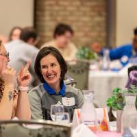 three people at table pointing and talking